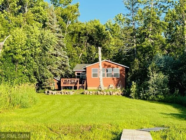 rear view of house featuring a wooden deck and a lawn