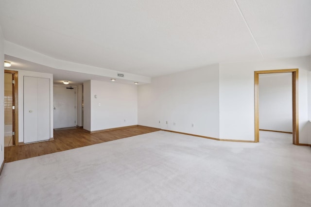carpeted empty room featuring baseboards