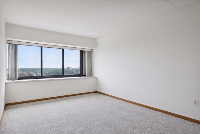 carpeted spare room featuring baseboards
