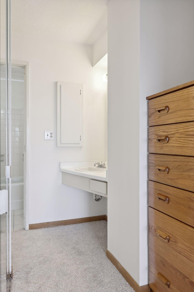 bathroom featuring baseboards and a sink