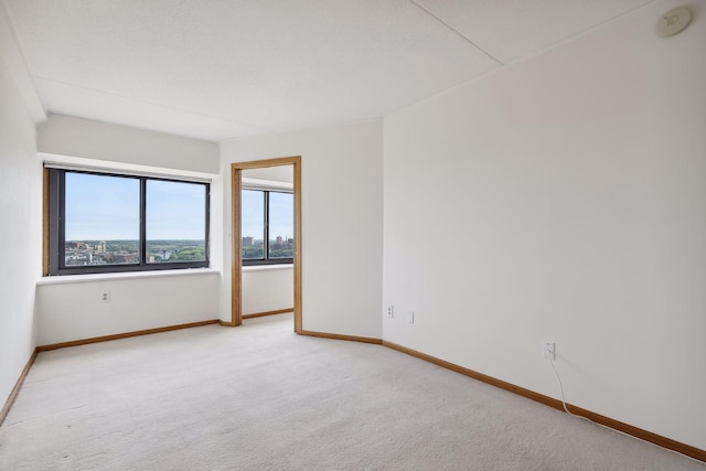 empty room featuring baseboards and carpet floors