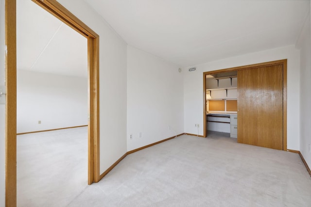 unfurnished bedroom featuring a closet, carpet, and baseboards