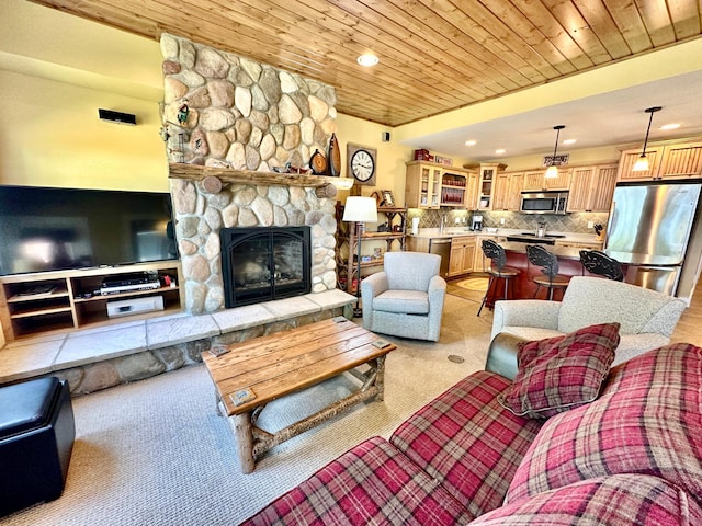 living room with a stone fireplace, light colored carpet, and wooden ceiling