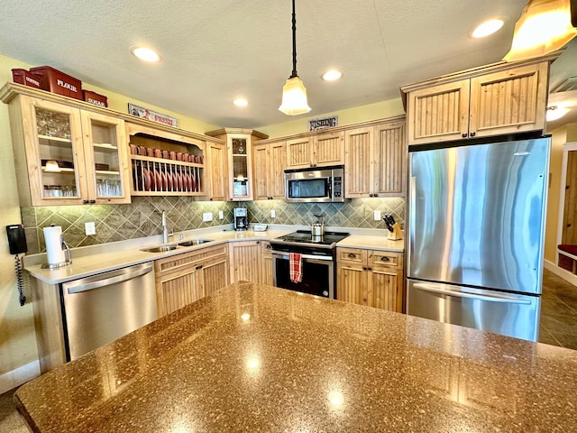 kitchen with appliances with stainless steel finishes, sink, backsplash, a textured ceiling, and hanging light fixtures