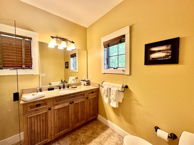 bathroom with toilet, a shower with shower door, and vanity