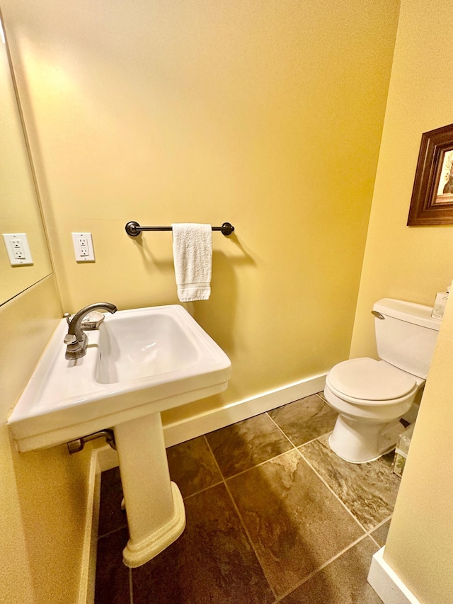 bathroom with toilet and tile patterned floors