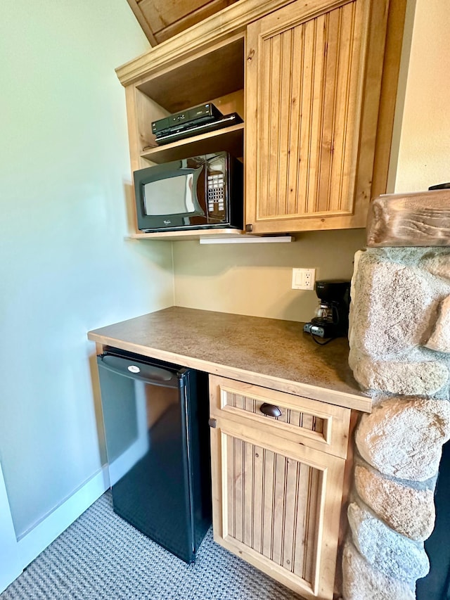 kitchen with light brown cabinets and black appliances