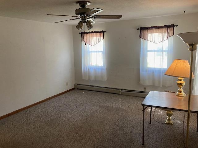 interior space with ceiling fan and baseboard heating