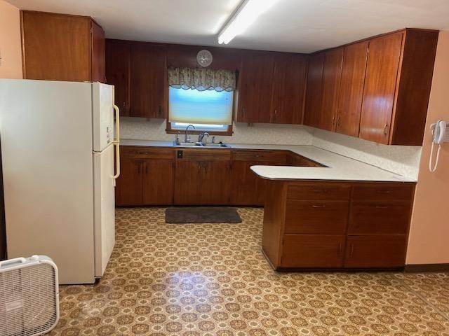 kitchen with decorative backsplash, sink, and white fridge