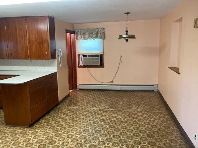 kitchen with hanging light fixtures, a baseboard heating unit, and cooling unit