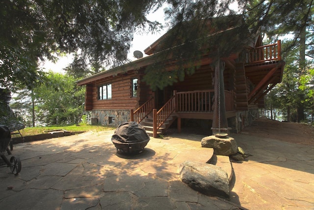 back of house with a fire pit and a patio