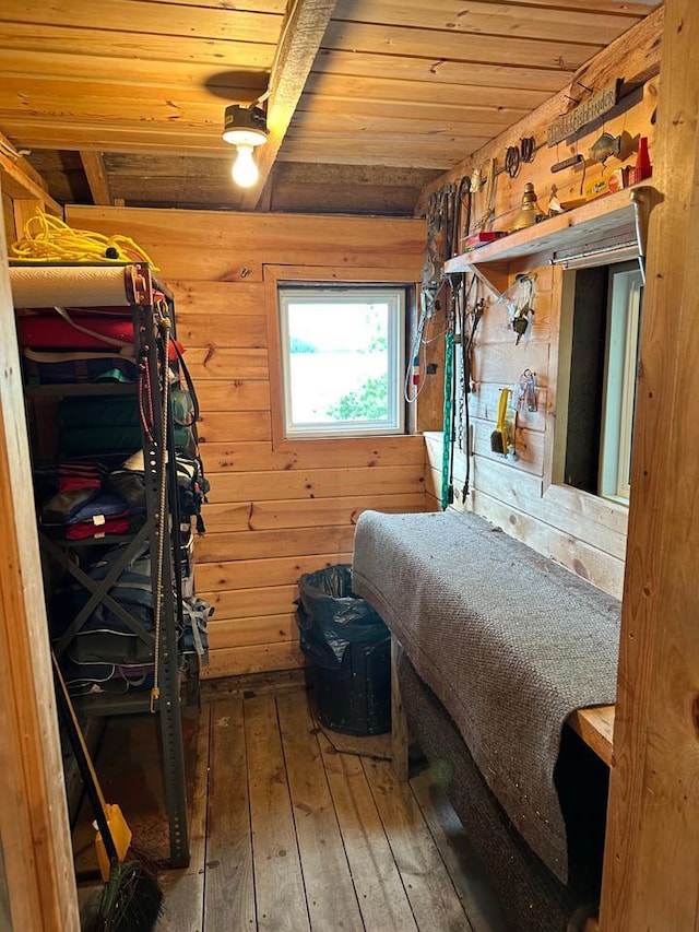 bedroom with hardwood / wood-style floors, wood walls, and wooden ceiling