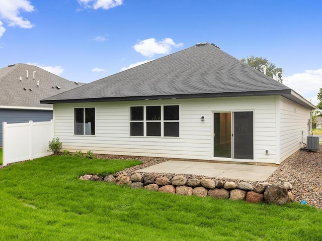 rear view of house with roof with shingles, a lawn, a patio area, fence, and cooling unit