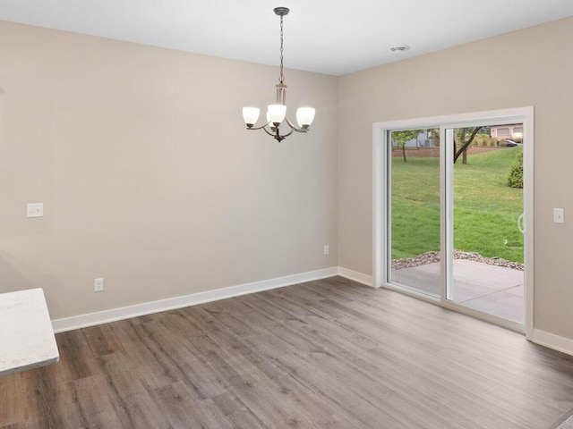 empty room featuring dark wood-style floors, baseboards, and an inviting chandelier