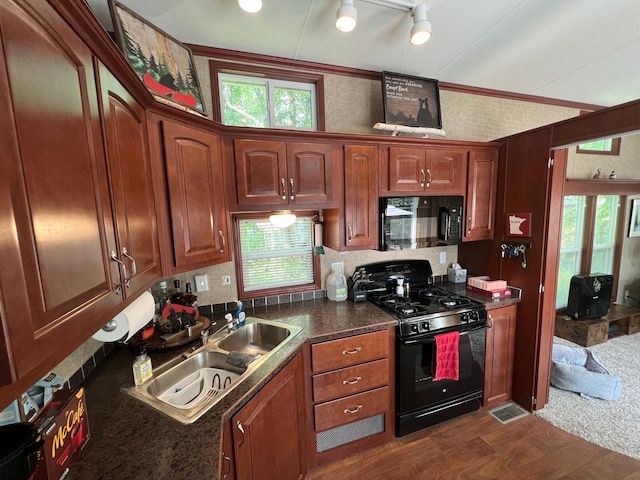 kitchen with track lighting, tasteful backsplash, sink, crown molding, and black appliances