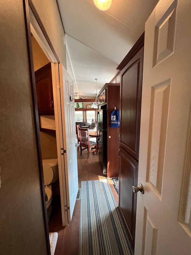 hallway with a notable chandelier and dark wood-type flooring