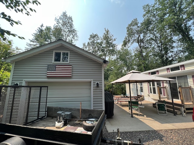 back of house featuring a wooden deck and a patio area