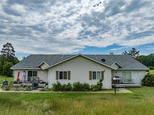 back of property with a deck, a yard, and a patio