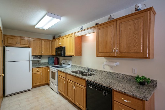 kitchen with dark stone counters, light tile floors, black appliances, and sink