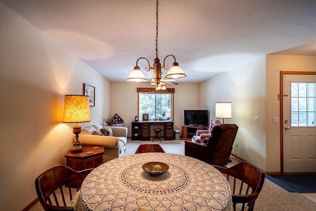 carpeted dining area with a notable chandelier