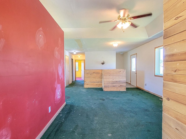 spare room with ceiling fan and dark carpet