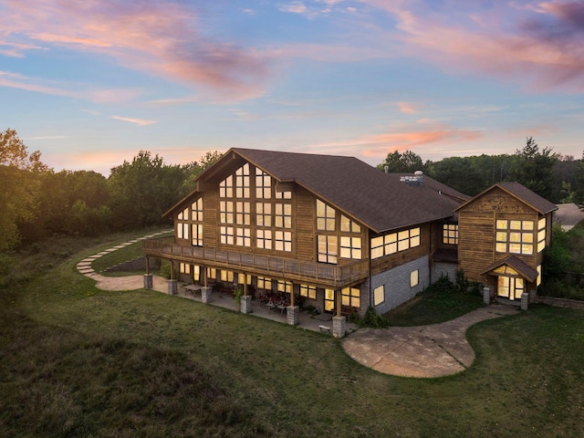 back house at dusk featuring a yard