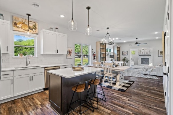 kitchen with dark hardwood / wood-style floors, tasteful backsplash, stainless steel dishwasher, hanging light fixtures, and a center island