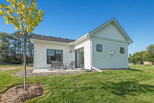 rear view of property featuring a patio and a yard