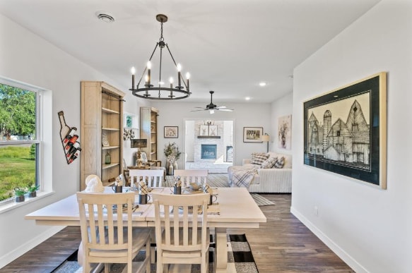 dining space with a wealth of natural light, dark hardwood / wood-style floors, and ceiling fan with notable chandelier