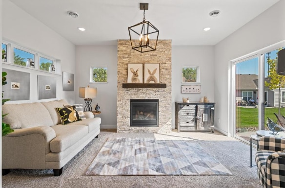 carpeted living room with a chandelier and a fireplace