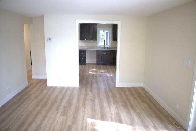 empty room featuring sink and light wood-type flooring