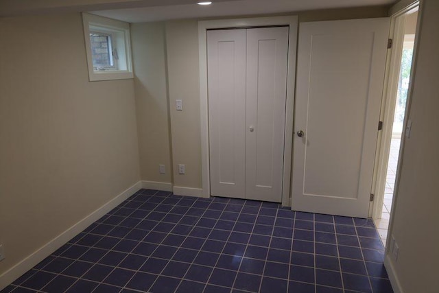 unfurnished bedroom featuring a closet and dark tile patterned floors