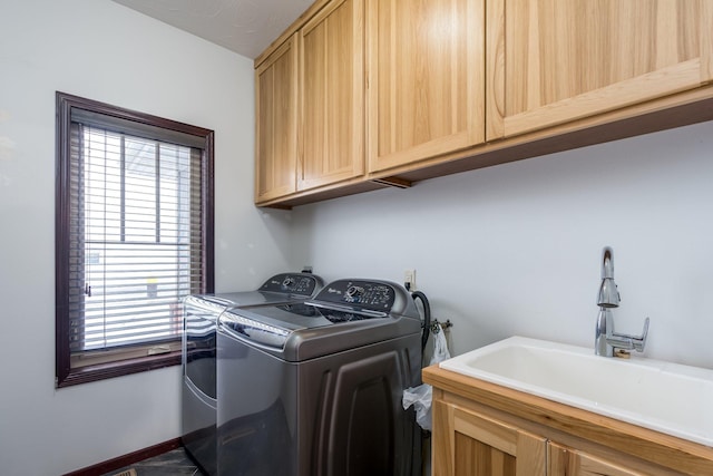 laundry room with a healthy amount of sunlight, sink, cabinets, and washing machine and clothes dryer