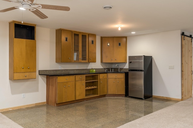 kitchen featuring sink, stainless steel fridge, ceiling fan, and a barn door