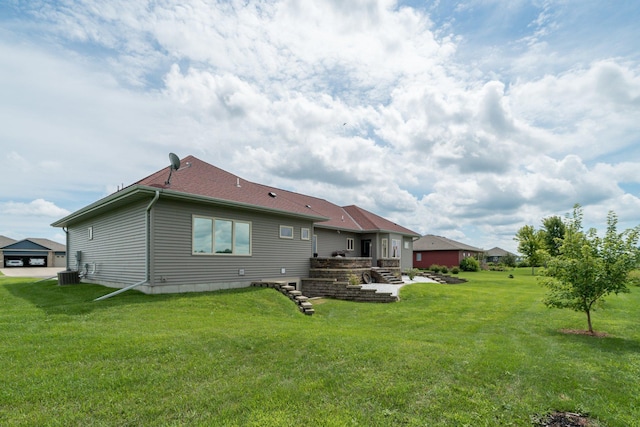 back of house featuring central AC unit and a yard