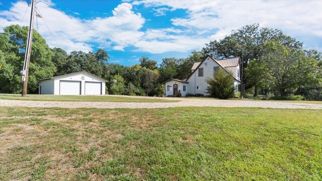 view of property exterior featuring an outdoor structure, a garage, and a lawn