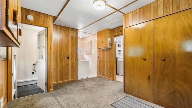 interior space with wood walls, carpet flooring, and washer / dryer