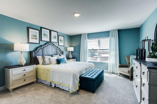 bedroom featuring light colored carpet and a textured ceiling