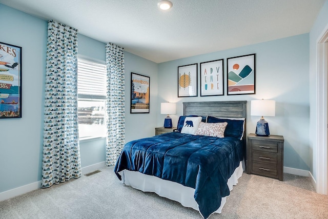 carpeted bedroom featuring multiple windows and a textured ceiling