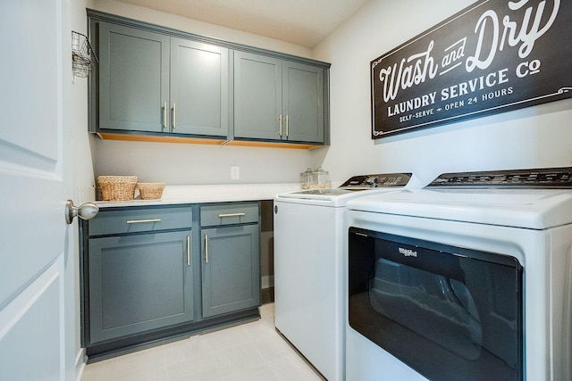 clothes washing area with cabinets and washer and dryer