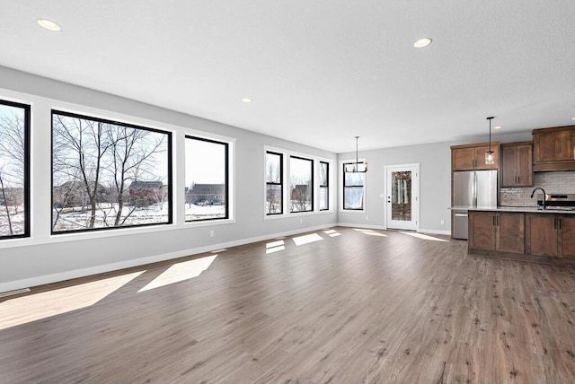 unfurnished living room with sink and wood-type flooring