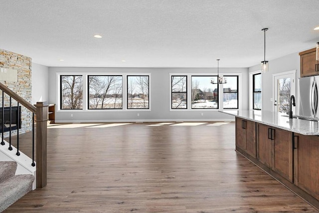 kitchen featuring light stone countertops, a textured ceiling, sink, and dark wood-type flooring