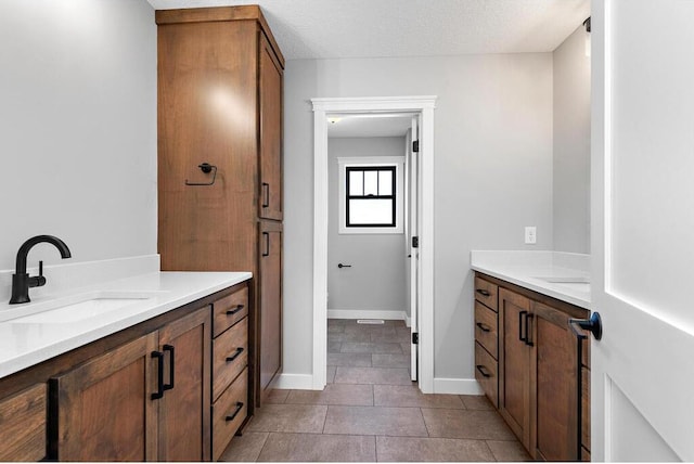 bathroom featuring tile floors, a textured ceiling, and vanity