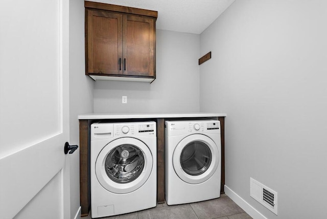 washroom featuring light tile flooring, cabinets, and independent washer and dryer