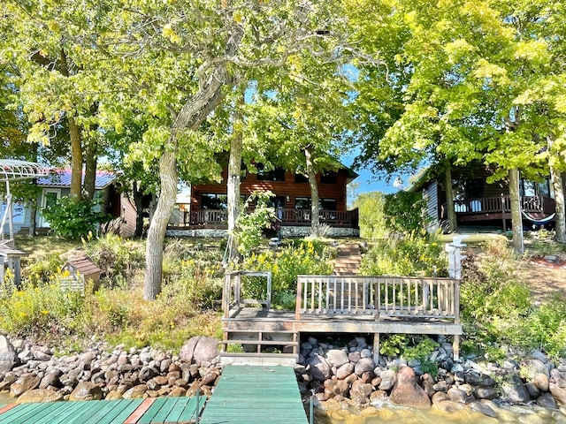 rear view of house with a deck with water view