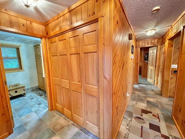 29724 387th St, Waubun, MN 56589 - hall with wooden walls, a textured ceiling, and light stone finish floors