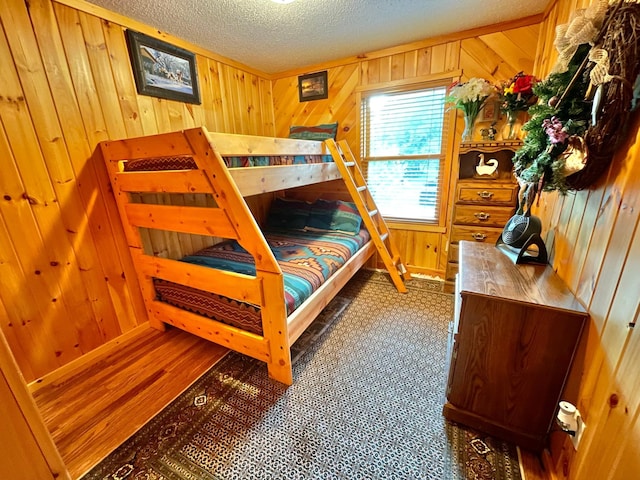 29724 387th St, Waubun, MN 56589 - bedroom with wooden walls, a textured ceiling, and wood finished floors