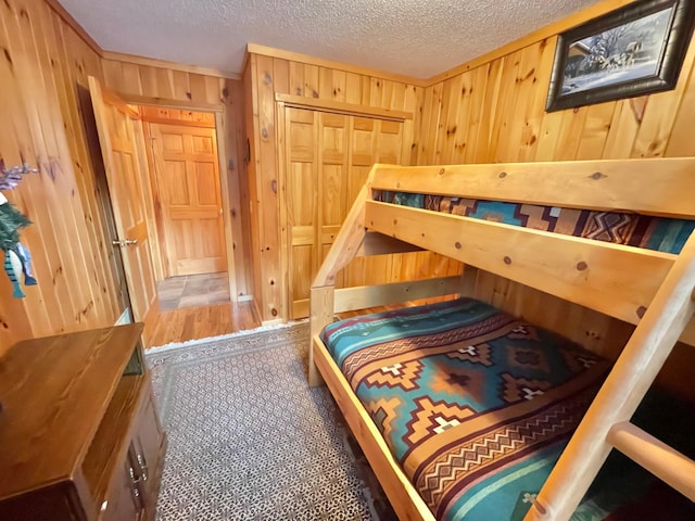 29724 387th St, Waubun, MN 56589 - bedroom featuring wooden walls, a textured ceiling, and a closet