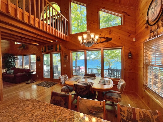 29724 387th St, Waubun, MN 56589 - dining room featuring wood walls, a chandelier, wood finished floors, a water view, and healthy amount of natural light