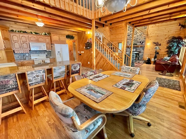 29724 387th St, Waubun, MN 56589 - dining room featuring wood walls, stairs, light wood-style floors, and a chandelier